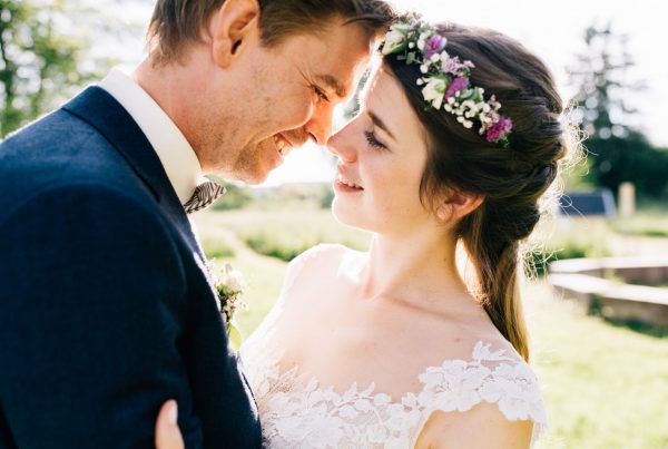 Hochzeitsfotograf salzburg paarfoto vom Hochzeitspaar kurz vorm Küssen mit schönem Sonnenlicht. Bräutigam mit Anzug und Braut mit Brautkleid